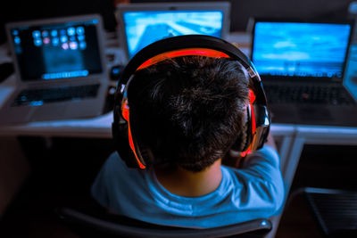 Rear view of boy paying video game