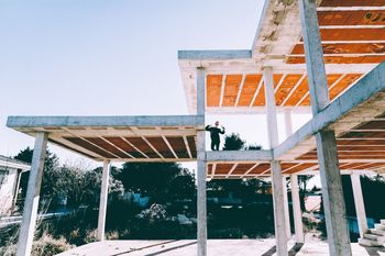 Woman standing on built structure against sky