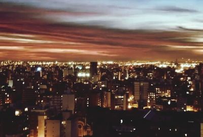 Illuminated cityscape against sky at night