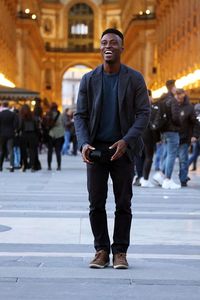 Full length portrait of young man on street in city