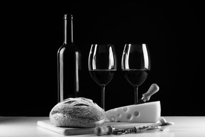 Wine glasses on table against black background