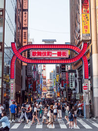 People walking on street against buildings in city