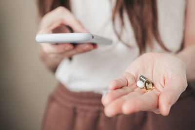 Vitamins for every day and a phone in the hands of the girl. spirulina, fish oil and magnesium 