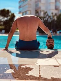 Midsection of shirtless man in swimming pool