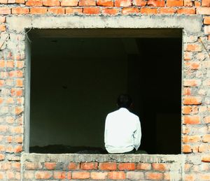 Full length of man on brick wall