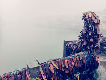 Clothes drying on clothesline by sea against sky