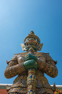 Low angle view of statue against temple against clear sky