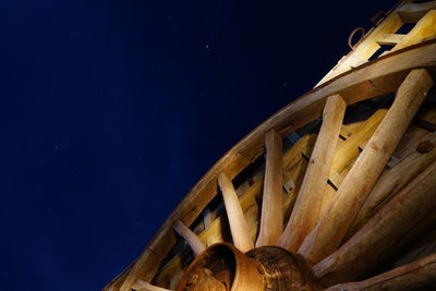 Low angle view of a old car wheel against sky at night