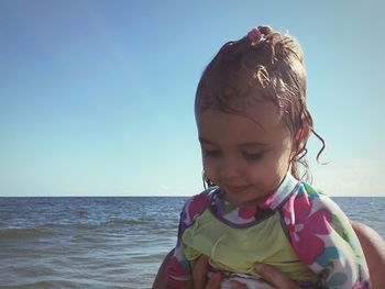 Cute girl at beach against blue sky