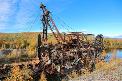 Abandoned ship on field against sky