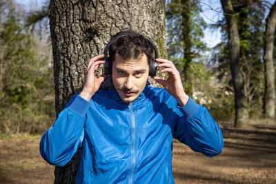 Beautiful man with blue eyes and mustache listening to music while exercising.