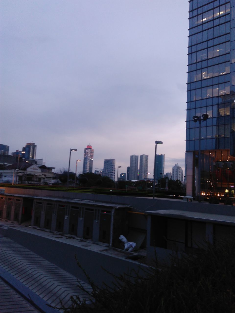 MODERN BUILDINGS IN CITY AGAINST SKY AT DUSK