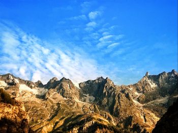 Low angle view of mountain range against blue sky