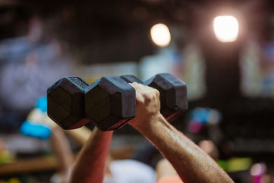 Cropped hands of man lifting dumbbells