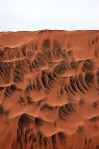 Sand dune in desert against clear sky