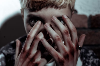 Close-up portrait of young woman with dirty hands