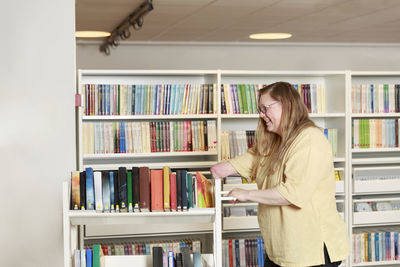 Librarian pushing book trolley forward