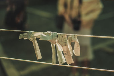 Close-up of prayer texts hanging on string