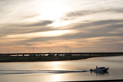 Bridge over sea against sky during sunset