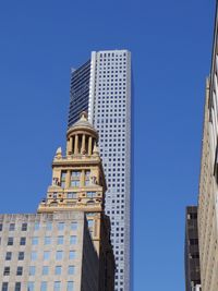 Low angle view of skyscrapers against clear blue sky