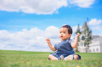 Cute boy on field against sky