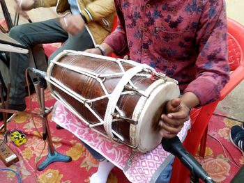 Midsection of man playing guitar