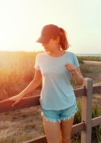 Rear view of young woman standing against clear sky