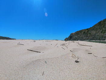 Scenic view of beach against clear blue sky