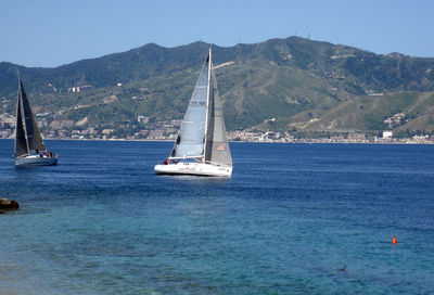 Sailboat sailing on sea against sky