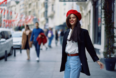 Portrait of young woman standing in city