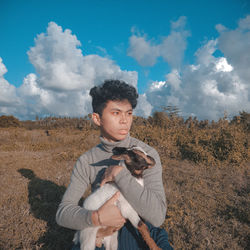 Full length of young man standing on field against sky