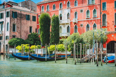 Boats moored in canal against buildings in city