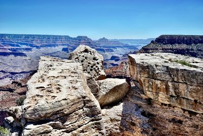 Rock formations on landscape against clear blue sky