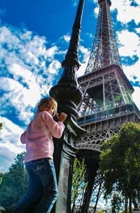 Low angle view of woman standing against sky