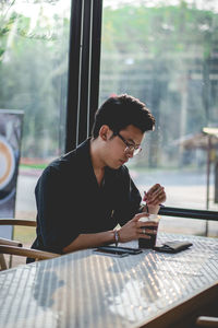 Young man drinking coffee at restaurant