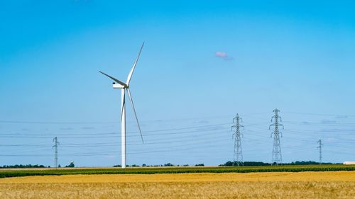 Windmill on field against sky