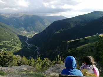 Rear view of children on mountain against sky