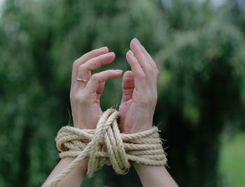 Cropped hands tied with rope