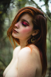 Close-up of topless woman standing in forest