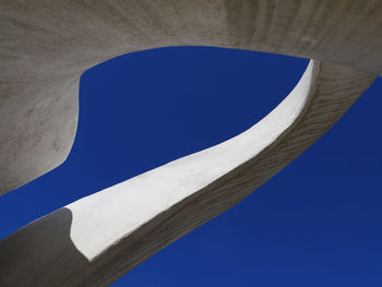 Low angle view of sculpture against clear blue sky on sunny day