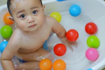 High angle portrait of naked baby boy in bathtub at home