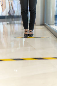 Low section of woman standing on tiled floor