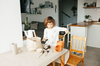 Portrait of boy sitting on table at home