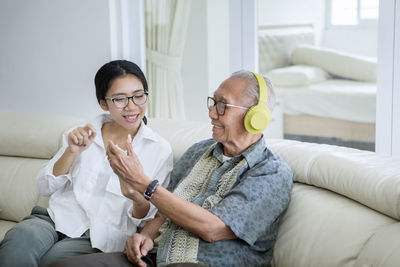 Grandchild teaching grandfather to use headphones