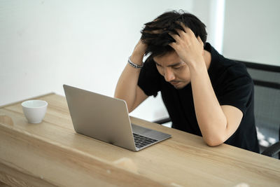 Senior woman using smart phone while sitting on table