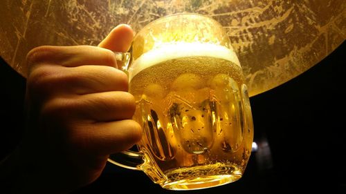 Close-up of hand holding beer glass