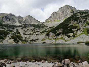 Scenic view of lake by mountains against sky