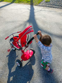 High angle view of girl riding toy car on road