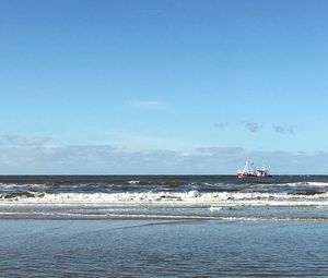 Boat sailing in sea against blue sky