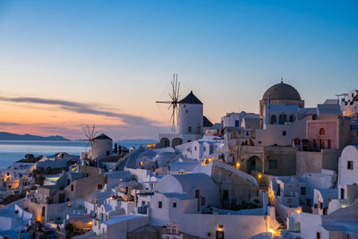 Buildings in city against sky during sunset